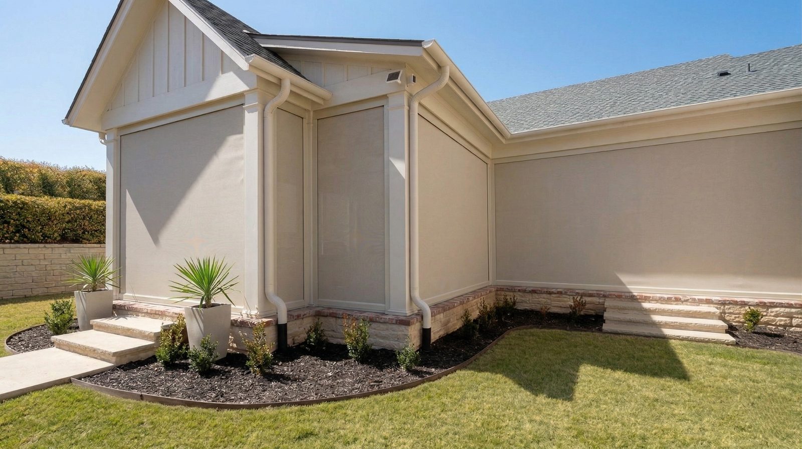 Multi-panel motorized SunPro patio shades enclosing a Westlake covered patio with views of the backyard